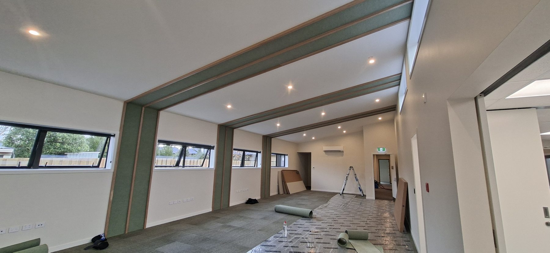 Freshly painted interior with cream walls, sage green feature bands and timber trim
